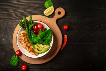 Turkish cuisine concept. Baked chicken garnished with asparagus and tomatoes. banner menu recipe place for text.
