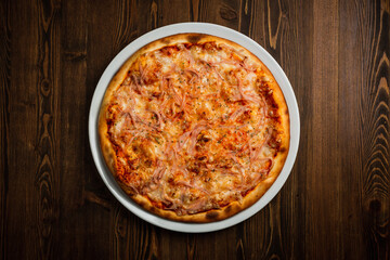 Ham and cheese pizza, wooden background, low key top view