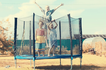children jumping on a trampoline, girlfriends having fun in the summer in a recreation park on a...