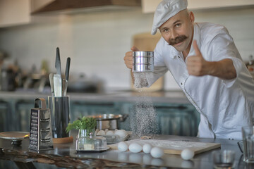 french chef in the kitchen preparing food, cooking, haute cuisine, man with mustache
