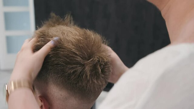 WARSAW, POLAND - June 10, 2019: close up of stylist uses hands to finish hair styling