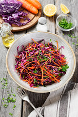 Coleslaw salad of red cabbage with carrots on rustic wooden background