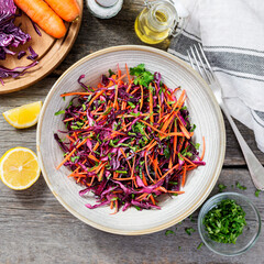 Coleslaw salad of red cabbage with carrots on rustic wooden background