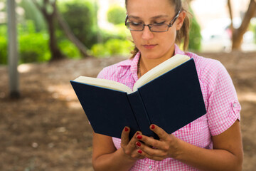 Woman reading a book outside.