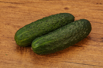 Green fresh cucumbers over background
