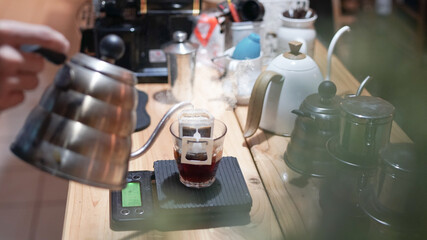 Drip brewing, filtered coffee, or pour-over is a method which involves pouring hot water over roasted, ground coffee beans contained in a filter, background.