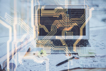 Computer on desktop in office with technology theme hologram. Multi exposure. Tech concept.