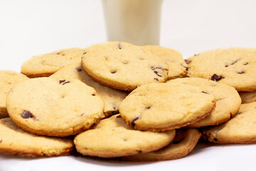 Delicious chocolate chip cookies plate with a glass of milk on the background.  on a white Isolated background