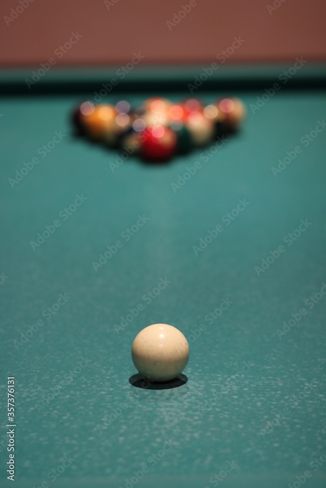 Sticker closeup shot of a white billiard ball with colorful balls in the background