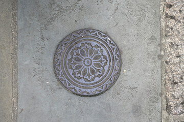 round manhole cover decorated with circles and a floral pattern 2
