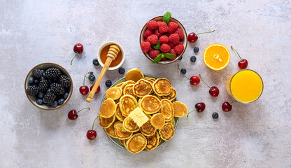 A heap of mini cereal pancakes. Traditional american breakfast with berries, maple syrup, and fresh...