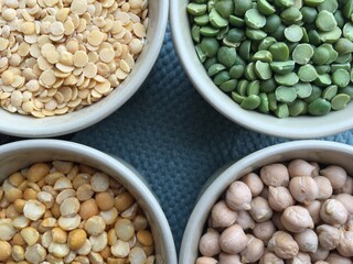 Round bowls with legumes, peas, chickpeas and lentils on a wicker grey background. High quality photo