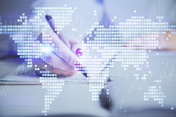 Obraz premium International business hologram over hands taking notes background. Concept of success. Multi exposure