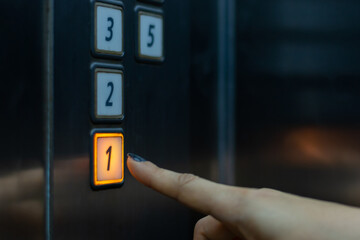finger presses the elevator button. hand reaches for the button of the elevator