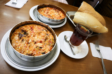 Menemen, a traditional Turkish breakfast serve with bread and tea. The food consist of tomatoes, eggs, onions and various spices.