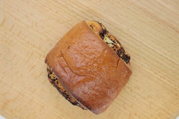 Beautiful delicious bun with poppy seeds located on a wooden surface