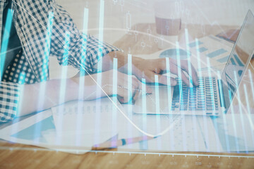Obraz premium Multi exposure of stock market chart with man working on computer on background. Concept of financial analysis.