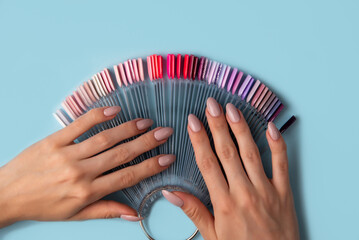 Woman holds in hands collection of color nail polish samples