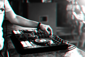 hands DJ playing electronic contemporary music on the mixer console at a concert in a nightclub