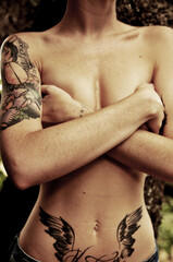 Mujer tatuada tapando pechos