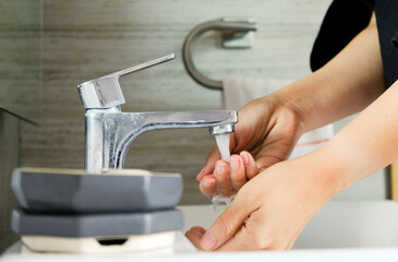 Washing hands. Focus on the tap.