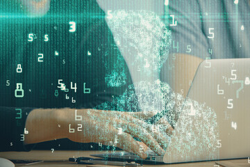 Multi exposure of data internet theme hologram with man working on computer on background. Concept of innovation.