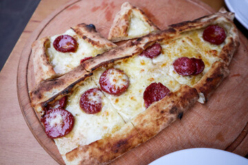 Traditional Turkish pizza. Turkish pide pizza with molten cheese and salami.