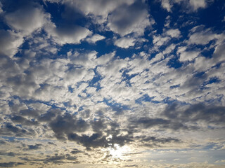 Blue sky clouds background. Beautiful landscape with white clouds and sun on sky