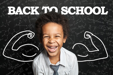 Happy successful laughing kid student boy on chalkboard background. Back to school concept