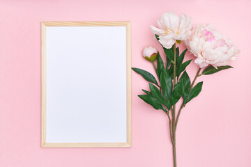 White mock up frame and pink flowers on a multi-colored background