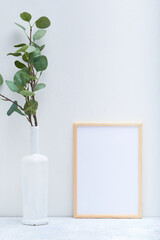 Stylish white mock up with vertical poster and plant in a vase