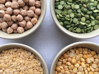 Round bowls with different legumes, peas, chickpeas and lentils on a white background. Place for text. High quality photo