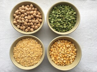 Round bowls with different legumes, peas, chickpeas and lentils on a white background. High quality photo
