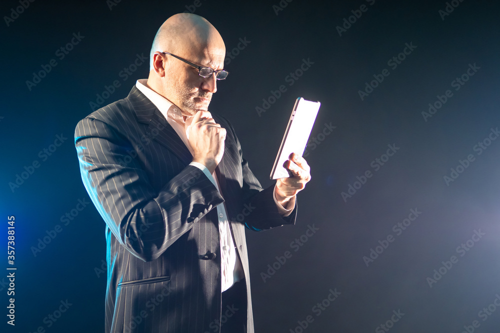 Poster getting information using an electronic tablet. a man in a black suit looks at information on a tabl