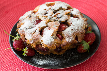 The cake with strawberry on the red background.