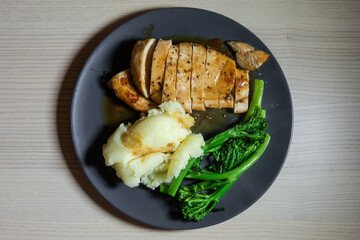 A plate of honey soy chicken breast, mashed potatoes, and broccolini.