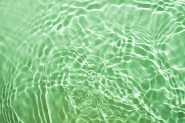 Green splashing cosmetic moisturizer, micellar water, toner, or emulsion background