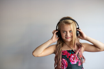 
Happy girl listening to music on headphones and dancing isolated on gray background,studio shot