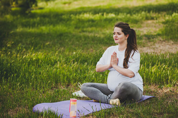Fototapeta na wymiar Healthy pregnant woman doing yoga in nature outdoors.