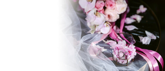 Elegant wedding accessories of an attractive bride. Wedding rings, shoes, bridal bouquet, floral arrangements, veil. Copy space for text. Background for greeting card or invitation.