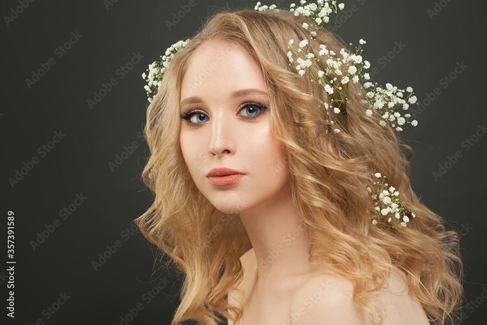 Wall mural Cheerful lady with blonde curly hair and white flowers, beautiful face closeup