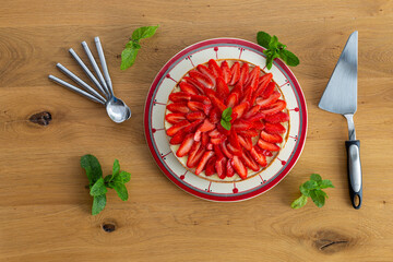 Strawberry pie on a wooden table with mint leaves