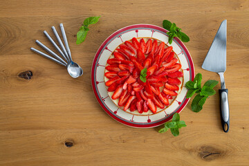 Strawberry pie on a wooden table with mint leaves