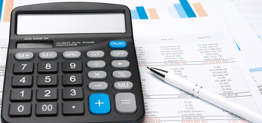Calculator on financial papers at the table close up