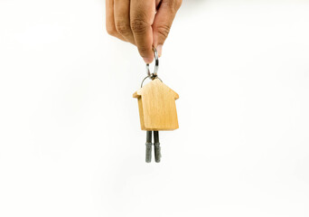 Conceptual image of house keys hand-over after completed home financing process. Keys with wooden key chain change hands. Blank space for texts. Focus on wooden keys; other on gradient blur.
