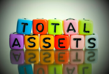 Conceptual of total asset a balance sheet items financial statements spelled on colorful alphabet beads. Isolated over reflective dark background. Focus on 