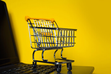 End of online sales. Online shopping, shopping cart on laptop keyboard.