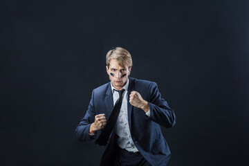 young man in a business suit rolled up his sleeves and Boxing. Aggressive business, concept.