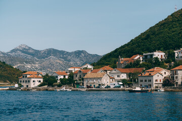 Fototapeta na wymiar The coastline of the city of Lepetane in Montenegro, near the ferry crossing through Kotor Bay.