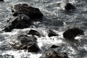 sunset on the beach of the Canary coast with the sun setting on a rocky beach with a nice cloudy sky